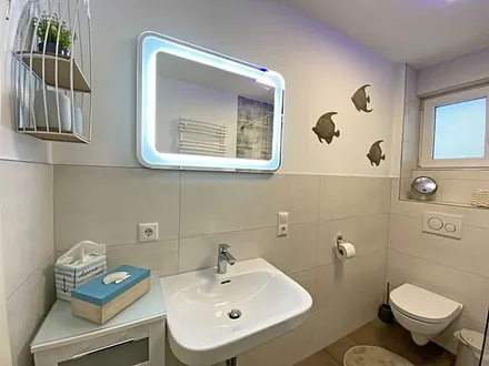 Tageslicht-Bad mit offener Glasdusche mit niedrigem Einstieg, Waschplatz, WC, Kosmetikspiegel, Fön, Handtuchtrockner sowie eine Fußbodenheizung