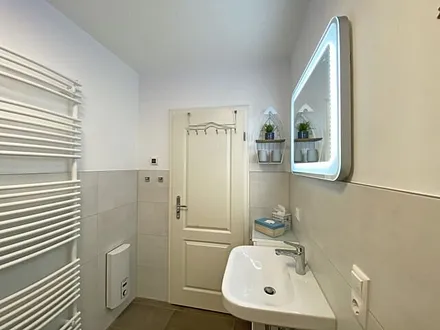 Tageslicht-Bad mit offener Glasdusche mit niedrigem Einstieg, Waschplatz, WC, Kosmetikspiegel, Fön, Handtuchtrockner sowie eine Fußbodenheizung