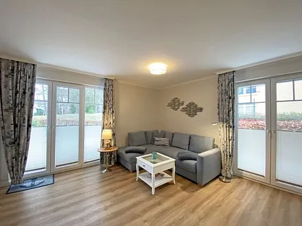 Wohnbereich mit gemütlicher Couch (Aufbettung für die 3. Person, Liegefläche 1,60 m x 2,00 m), Couchtisch, Leselampe, Lowbord mit Smart-TV, DAB-Radio mit USB-Anschluss sowie Bluetooth Anschluss