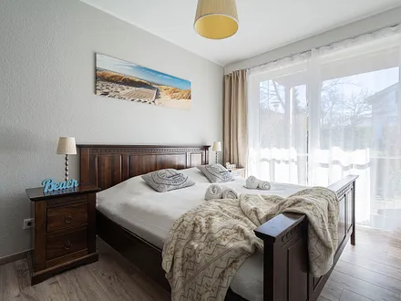 Das 1. Schlafzimmer mit einem Doppelbett und Zugang zur Ost-Terrasse