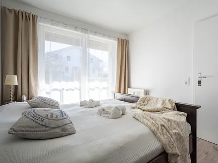 Das 1. Schlafzimmer mit einem Doppelbett und Zugang zur Ost-Terrasse