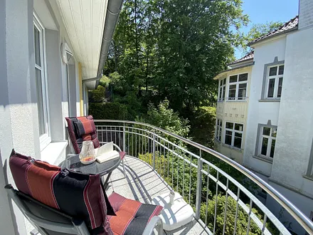 bestuhlter Balkon mit etwas Blick ins Grüne