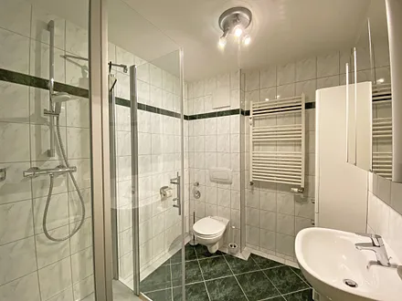 Badezimmer mit Dusche (niedriger Einstieg), WC, Schränken, Kosmetikspiegel und Fön