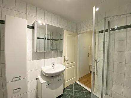 Badezimmer mit Dusche (niedriger Einstieg), WC, Schränken, Kosmetikspiegel und Fön