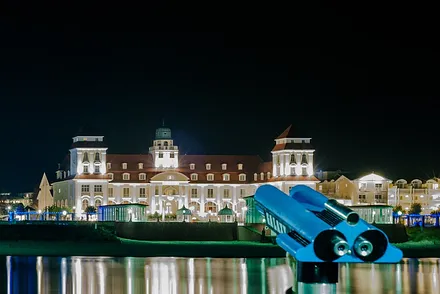 Binzer Kurhaus bei Nacht, von der Seebrücke aus gesehen