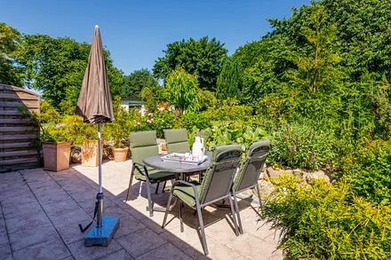 Die große möblierte Terrasse schaut in den Garten.