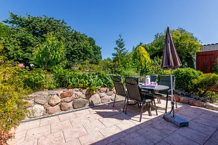 Die große möblierte Terrasse schaut in den Garten.