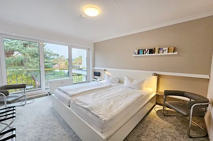 Schlafzimmer mit Doppelbett und Blick ins Grüne