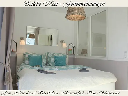 Das Schlafzimmer mit Doppelbett mit Toppern, seniorenfreundlicher Einstiegshöhe