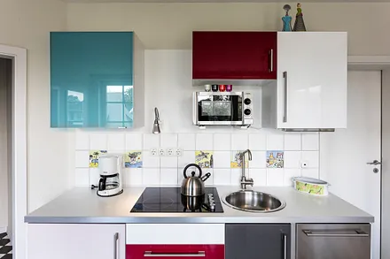 Die Küchenzeile mit Geschirrspüler und Mikrowelle.