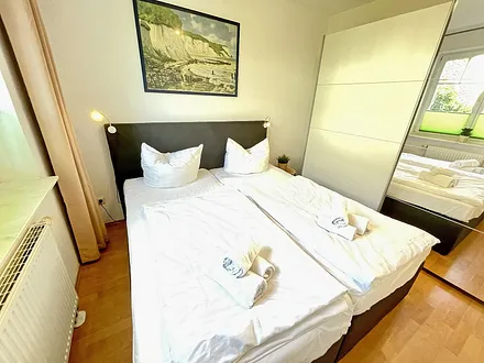 Schlafzimmer mit Doppelbett (1,80 m x 2,00 m), Nachttischablagen und einen Kleiderschrank