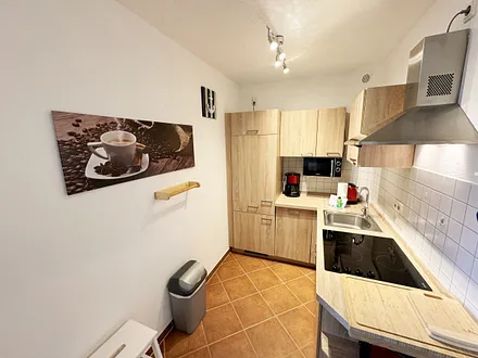 Küchenzeile mit Geschirrspüler, Cerankochfeld, Kühlschrank mit Eisfach, Mikrowelle, Kaffeemaschine, Wasserkocher und ein Toaster