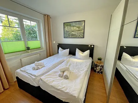 Schlafzimmer mit Doppelbett (1,80 m x 2,00 m), Nachttischablagen und einen Kleiderschrank