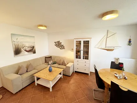 Wohnbereich mit Eckcouch (Aufbettung für die 3. Person, 1,20 m x 1,95 m), Couchtisch, Stehlampe, Vitrine sowie ein Sideboard mit Flachbild-TV