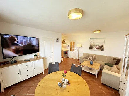 Wohnbereich mit Eckcouch (Aufbettung für die 3. Person, 1,20 m x 1,95 m), Couchtisch, Stehlampe, Vitrine sowie ein Sideboard mit Flachbild-TV