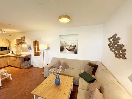 Wohnbereich mit Eckcouch (Aufbettung für die 3. Person, 1,20 m x 1,95 m), Couchtisch, Stehlampe, Vitrine sowie ein Sideboard mit Flachbild-TV