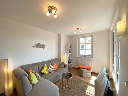 Wohnbereich mit gemütlicher Eckcouch + Hocker, Leselampe, Regal mit Urlaubslektüre sowie Gesellschaftsspielen,TV-Board mit LED-TV sowie Musikanlage mit DAB-Radio von Teufel 