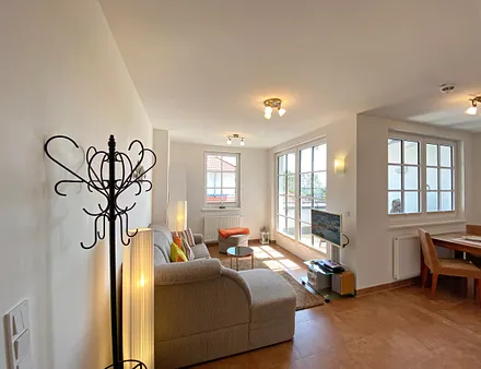 Wohnbereich mit gemütlicher Eckcouch + Hocker, Leselampe, Regal mit Urlaubslektüre sowie Gesellschaftsspielen,TV-Board mit LED-TV sowie Musikanlage mit DAB-Radio von Teufel 