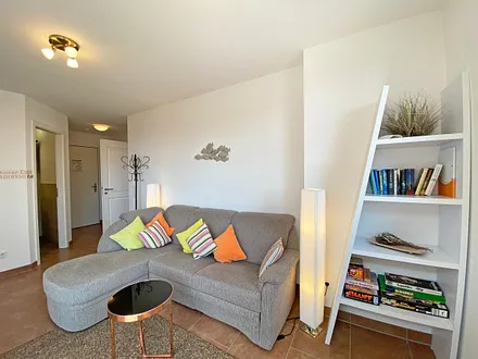 Wohnbereich mit gemütlicher Eckcouch + Hocker, Leselampe, Regal mit Urlaubslektüre sowie Gesellschaftsspielen,TV-Board mit LED-TV sowie Musikanlage mit DAB-Radio von Teufel 