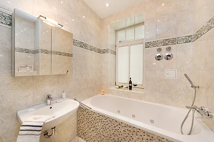 Das schöne Bad mit Whirlwanne, Dusche, WC und Fön sowie Fußbodenheizung.