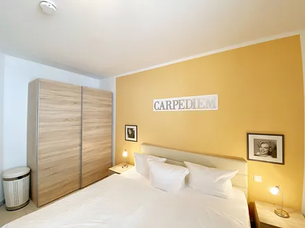 Schlafzimmer mit Doppelbett (1,80 m x 2,00 m), Nachttischablagen mit Beleuchtung, Kleiderschrank und einem Spiegel