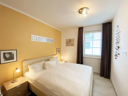 Schlafzimmer mit Doppelbett (1,80 m x 2,00 m), Nachttischablagen mit Beleuchtung, Kleiderschrank und einem Spiegel