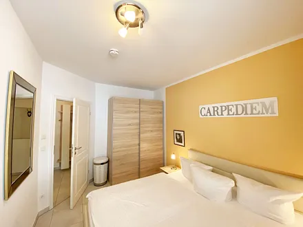 Schlafzimmer mit Doppelbett (1,80 m x 2,00 m), Nachttischablagen mit Beleuchtung, Kleiderschrank und einem Spiegel