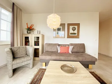 Wohnbereich mit Couch (Aufbettungsmöglichkeit für die 3. Person, 1,60 m x 2,00 m), Couchtisch, Sessel, Vitrine, TV-Board mit Flachbild-TV, Musikanlage mit CD-Player und Radio