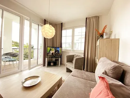 Wohnbereich mit Couch (Aufbettungsmöglichkeit für die 3. Person, 1,60 m x 2,00 m), Couchtisch, Sessel, Vitrine, TV-Board mit Flachbild-TV, Musikanlage mit CD-Player und Radio