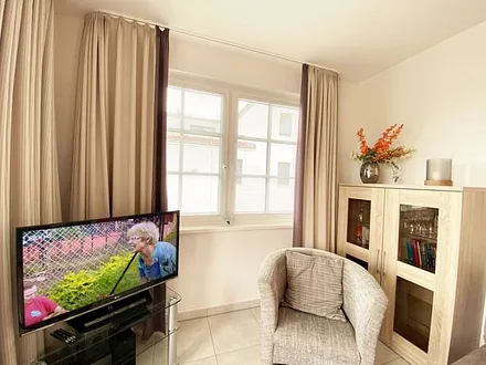 Wohnbereich mit Couch (Aufbettungsmöglichkeit für die 3. Person, 1,60 m x 2,00 m), Couchtisch, Sessel, Vitrine, TV-Board mit Flachbild-TV, Musikanlage mit CD-Player und Radio