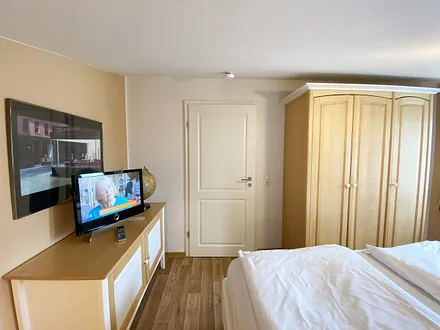 großes Schlafzimmer mit Doppelbett (1,80 m x 2,00 m), Nachttischablagen und Beleuchtung, Kleiderschrank, Sideboard sowie ein TV