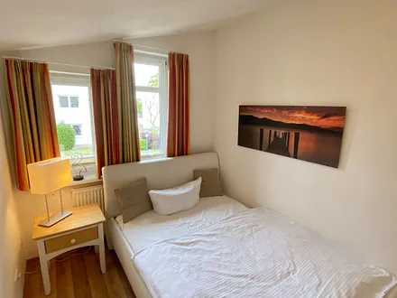 kleineres Schlafzimmer mit französischem Doppelbett (1,60 m x 2,00 m), Nachttischablage und Beleuchtung sowie ein Kleiderschrank