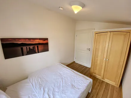 kleineres Schlafzimmer mit französischem Doppelbett (1,60 m x 2,00 m), Nachttischablage und Beleuchtung sowie ein Kleiderschrank