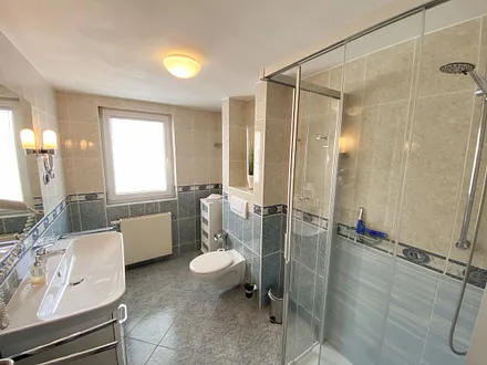 Tageslichtbad mit ebenerdiger Dusche, WC, Fön, Kosmetikspiegel sowie ein Waschtisch