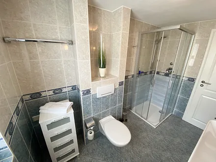 Tageslichtbad mit ebenerdiger Dusche, WC, Fön, Kosmetikspiegel sowie ein Waschtisch