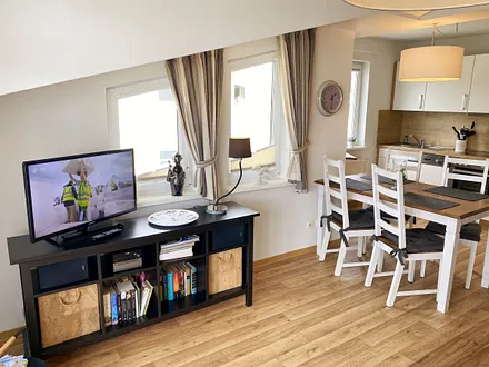 Wohnbereich mit bequemer Ledercouch, Lesesessel mit Hocker, Couchtisch, TV-Board mit Flachbild-TV, Musikanlage und Urlaubslektüre 