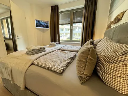 Schlafzimmer mit Boxspringbett ( 1,80 m x 2,00 m) in Komfort-Höhe, Insektenschutzgitter, großer Kleiderschrank, Nachttischablagen mit Beleuchtung, Smart-TV und ein Sideboard