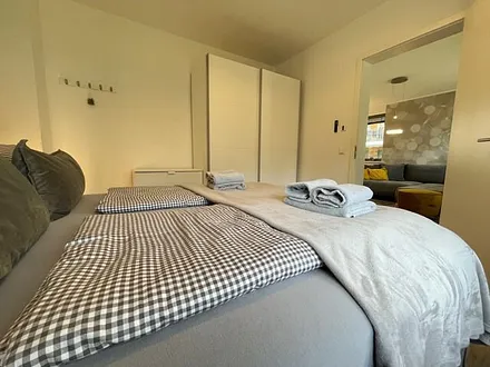 Schlafzimmer mit Boxspringbett ( 1,80 m x 2,00 m) in Komfort-Höhe, Insektenschutzgitter, großer Kleiderschrank, Nachttischablagen mit Beleuchtung, Smart-TV und ein Sideboard