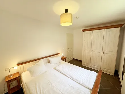 Schlafzimmer mit Doppelbett und Kleiderschrank