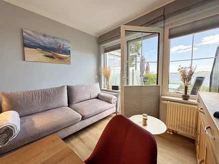 Wohnzimmer mit gemütlicher Couch und Seeblick