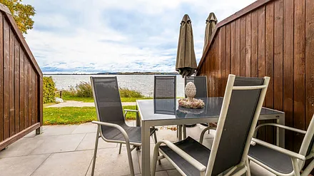 sonnige und bestuhlte Terrasse (Süd) mit Sonnenschirm und Seeblick