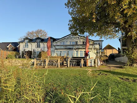 Blick vom Wasser auf das Haus Seeblick mit Restaurant
