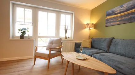 komfortabler Wohnbereich mit Couch (Aufbettungsmöglichkeit 1,40m x 1,90m), Couchtisch, Sessel, Stehlampe sowie einer Kommode mit Flachbild-TV