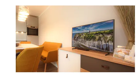 komfortabler Wohnbereich mit Couch (Aufbettungsmöglichkeit 1,40m x 1,90m), Couchtisch, Sessel, Stehlampe sowie einer Kommode mit Flachbild-TV