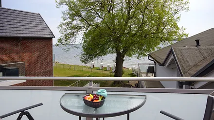 bestuhlter Balkon (Süd) mit Sonnenschirm und Seeblick