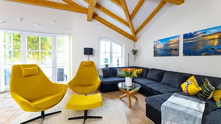 Wohnbereich mit einer Wohnlandschaft (Aufbettungsmöglichkeit für 5./6. Person), Couchtisch, 2 Relaxsessel, 2 Stehlampen, einen Kamin (Holz inklusive) sowie eine TV-Bank mit Flachbild-TV 