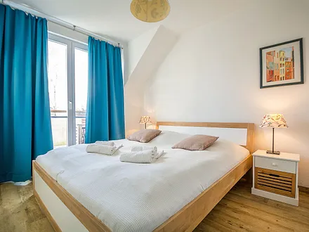 Das erste Schlafzimmer mit Doppelbett und Zugang zum Ost-Balkon