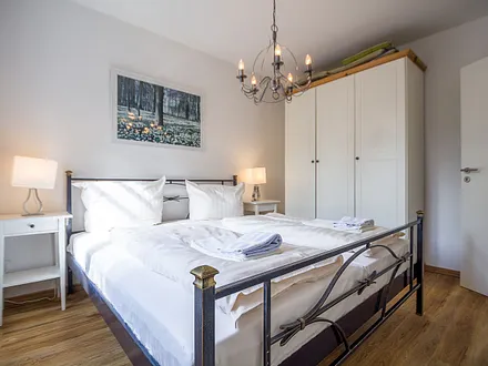 Das erste Schlafzimmer mit Doppelbett und einem großen Kleiderschrank