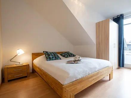 Das erste Schlafzimmer mit Doppelbett, Kleiuderschrank und Zugang zum Süd-Balkon