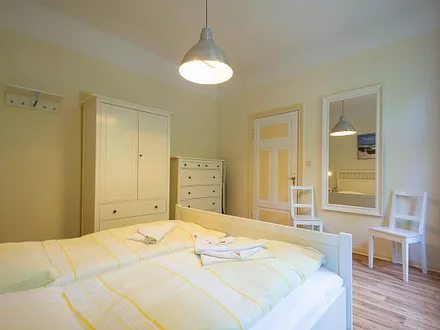 Das Schlafzimmer mit Doppelbett und Kleiderschrank